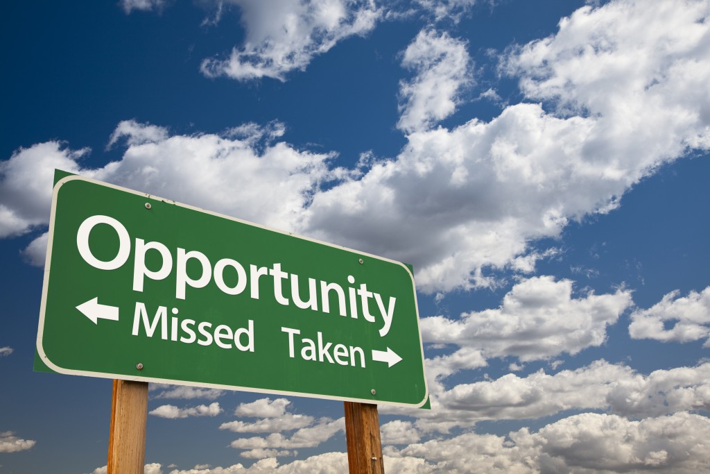 Opportunity Missed and Taken Green Road Sign Over Dramatic Blue Sky and Clouds.